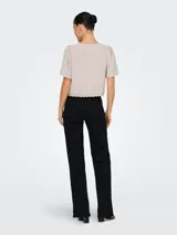 Top color gris claro con escote en V, mangas cortas abullonadas y cierre con lazo. Detalle de encaje en el escote y ruedo.