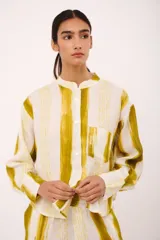 Camisa de lino italiano con estampado a rayas verticales en tonos amarillo y blanco, cuello mao y manga larga.