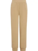 Pantalón de jogging color beige, de corte relajado, con cintura y tobillos elásticos, bolsillos laterales y logo pequeño en el lateral.