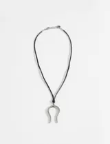 Collar con cordón negro y dije plateado en forma de herradura.