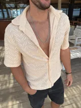 Camisa de hombre color beige, tejida con diseño geométrico, de corte recto y manga corta.