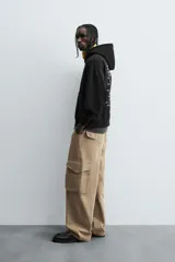 Pantalón cargo color beige, de corte relaxed fit, con bolsillos frontales, traseros con solapa y bolsillos laterales tipo parche con solapa.
