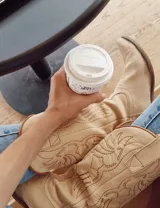 Botas de cuero negro con bordado decorativo en el caño y empeine, taco bajo y punta fina. Diseño de estilo cowboy.