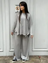 Pantalón de lanilla gris con lurex, corte palazzo y abertura en el lateral inferior.
