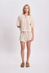 Top de punto crochet color crudo con mangas cortas y cuello redondo.