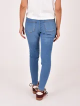 Jean de mujer, tiro medio-alto, color azul claro con lavado uniforme. Corte ajustado tipo skinny o slim fit.