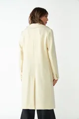 Abrigo de lana color marrón con cuello de solapa y cierre frontal de botones, con mangas largas y bolsillos.