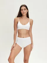 Top deportivo blanco sin costuras, con breteles finos y escote redondo.