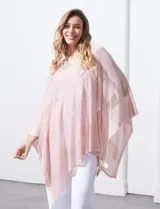 Poncho blanco de tejido calado con lurex, terminación asimétrica y cuello redondo.