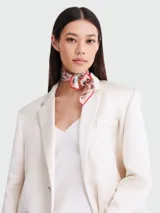 Pañuelo cuadrado de seda con estampado vibrante que incluye motivos de la Torre Eiffel, flores y elementos decorativos en tonos azul marino, blanco, naranja y rojo.