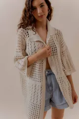 Saco calado negro tejido a máquina, con cuello tipo camisa y mangas 3/4.