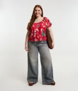 Blusa plus size con mangas cortas abullonadas y elástico en los hombros. Prenda confeccionada en viscolino y estampada con motivos de follajes y tucanes.