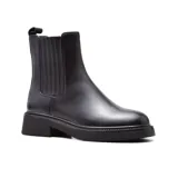 Bota Chelsea de cuero negro con elástico lateral, caña media y suela track.