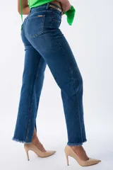 Pantalón de jean azul de corte recto con terminación desflecada y cadena dorada decorativa.