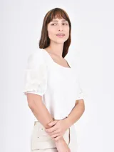 Remera negra de mangas cortas abullonadas con bordado floral en las mangas y escote cuadrado.