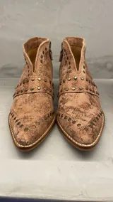 Bota de caña corta color cobre con tachas doradas, cierre lateral y taco de 5 cm.