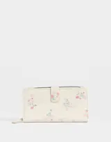 Billetera de cuerina color crema con estampado de flores y cierre con broche a presión.