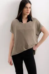 Blusa color beige de tejido de punto con lurex, de mangas cortas y corte holgado.