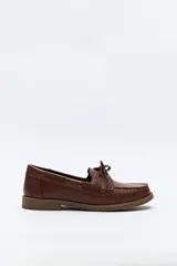 Zapato náutico color beige, de símil cuero, con cordones y suela marrón antideslizante.