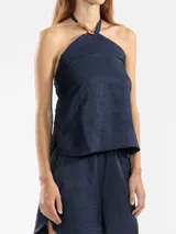 Top halter blanco de lino italiano con hilo metalizado y insignia de tigre removible.