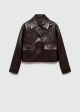 Chaqueta corta de poliuretano color marrón oscuro con textura, cuello camisero, manga larga con puños abotonados, dos bolsillos de solapa en la parte delantera y cierre frontal con botones.