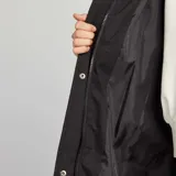 Campera larga acolchada negra con capucha, cierre frontal y bolsillos laterales.