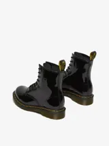 Bota acordonada de charol negro con costuras amarillas en la suela y tirador trasero con el logo de la marca.
