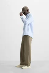 Camisa azul marino de corte regular fit, confeccionada en tejido de algodón Oxford. Tiene cuello abotonado, manga larga con puños abotonados, bolsillo de parche en el pecho y cierre frontal con botones.