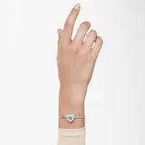 Pulsera rígida plateada con dije en forma de corazón adornado con circonitas blancas y una circonita azul en el centro.