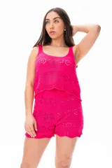 Conjunto tejido de hilo color fucsia, compuesto por un top sin mangas con diseño calado y un short con cintura elastizada y ruedo festoneado.