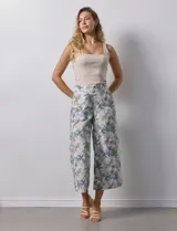 Pantalón crop de lino estampado con hojas en tonos verdes y azules. Tiene pretina trasera elastizada y bolsillos delanteros.