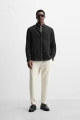 Pantalón negro de corte cropped, con cintura elástica ajustable con cordón, bolsillos laterales y traseros de vivo. El bajo tiene terminación con vuelta.