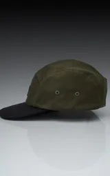 Gorra de cinco paneles color verde militar con visera negra y logo bordado en el frente.