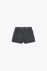 Shorts de tiro alto confeccionados en tejido con efecto lavado, cintura elástica ajustable con cordones, bolsillos laterales de vivo y tejido combinado en rib a tono.