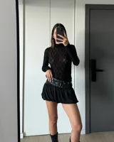 Polera de encaje negro de mangas largas.