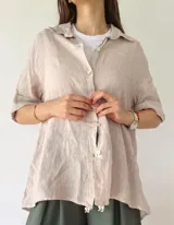 Camisa de 100% lino color beige, con botones frontales y corte holgado.