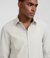 Camisa de hombre regular, de sastrería rayada celeste y blanco, con cuello solapa, abotonada y de manga larga.