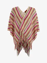 Poncho de punto multicolor con diseño de ondas en zigzag y flecos en el borde inferior.