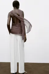 Top marrón con lunares blancos, cuello halter con fornitura dorada y bufanda integrada. Espalda descubierta y forro interior.