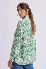 Camisa de manga larga con cuello clásico y estampado floral en tonos verde y blanco.