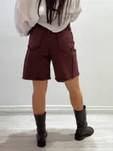 Bermuda marrón de gabardina elastizada con cinturón fino con tachas y detalles de flecos en el ruedo.