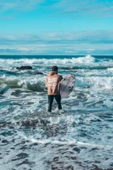 Buzo hoodie marrón con capucha y cordones ajustables. Estampado en la espalda con la frase "Glassy Waves", "Good Vibes" y una flor.