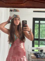 Vestido corto de lentejuelas color verde oliva, con escote en V, breteles finos cruzados en la espalda, cut-outs laterales y volado en el ruedo.