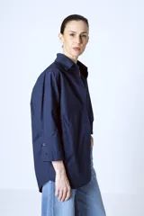 Camisa azul marino de corte holgado, con cuello clásico, cierre frontal con botones y mangas 3/4.