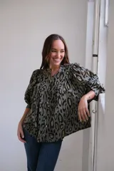 Camisa verde oliva con estampado animal print en tonos marrones y negros, cuello mao y mangas largas abullonadas.