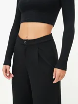 Pantalón negro de corte palazzo con cintura alta y botón.