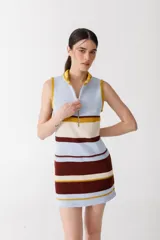 Vestido corto de punto con rayas horizontales en color rojo, marrón, beige y rosa. Tiene cuello alto con cierre de cremallera dorada y diseño sin mangas.