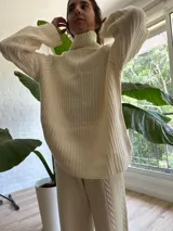 Conjunto de sweater y pantalón de punto color crema con diseño trenzado.