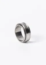 Anillo plateado de acero quirúrgico con tres ranuras que permiten que la parte central gire.