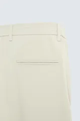 Pantalón largo de vestir gris claro con estampado de cuadros, corte slim fit y cintura elástica. Confeccionado en tejido con alta elasticidad, bolsillos frontales y cierre frontal con cremallera y botón.